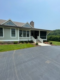 Professional residential landscaping with hardscaping, featuring a beautiful home with paved driveway and manicured lawn